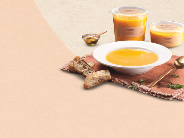 Fotografia de um prato de sopa com dois recipientes de sopa cozinha continente atrás.